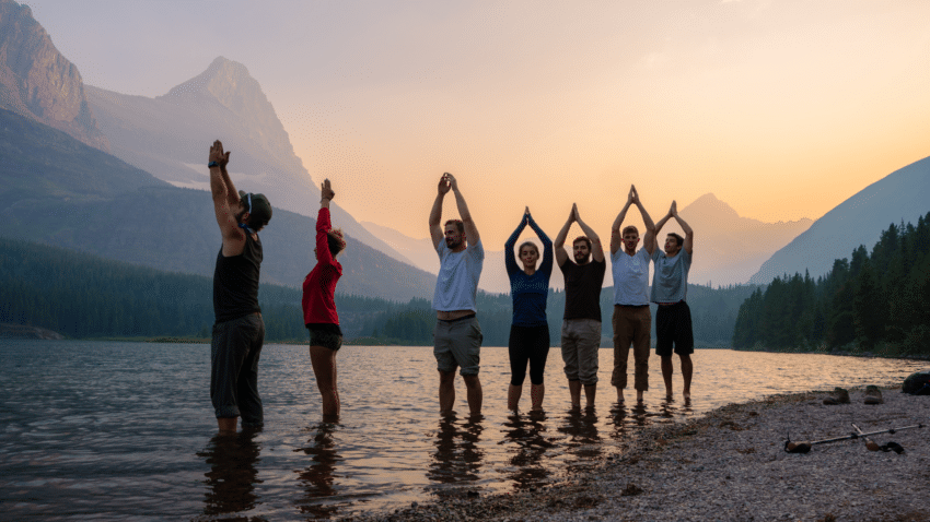 Group of people on a lake practicing yoga during sunset