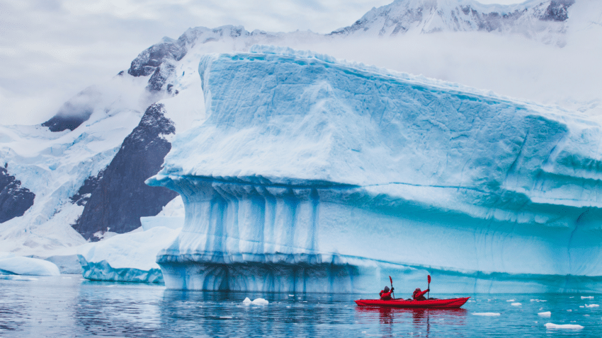 people kayaking around glacier