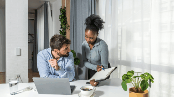 two-people-reviewing-work-laptop-clipboard