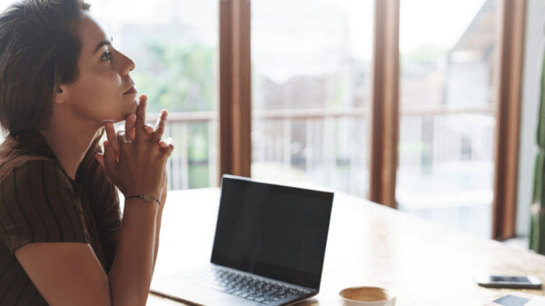 Attractive lucky successful businesswoman listening employees reports sit satisfied pleased near window, laptop opened drink coffee hold hands above chin thoughtful, thinking make decision.